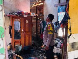 Asap hitam pekat membumbung dari sebuah rumah di tepi jalan