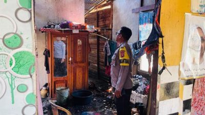 Asap hitam pekat membumbung dari sebuah rumah di tepi jalan